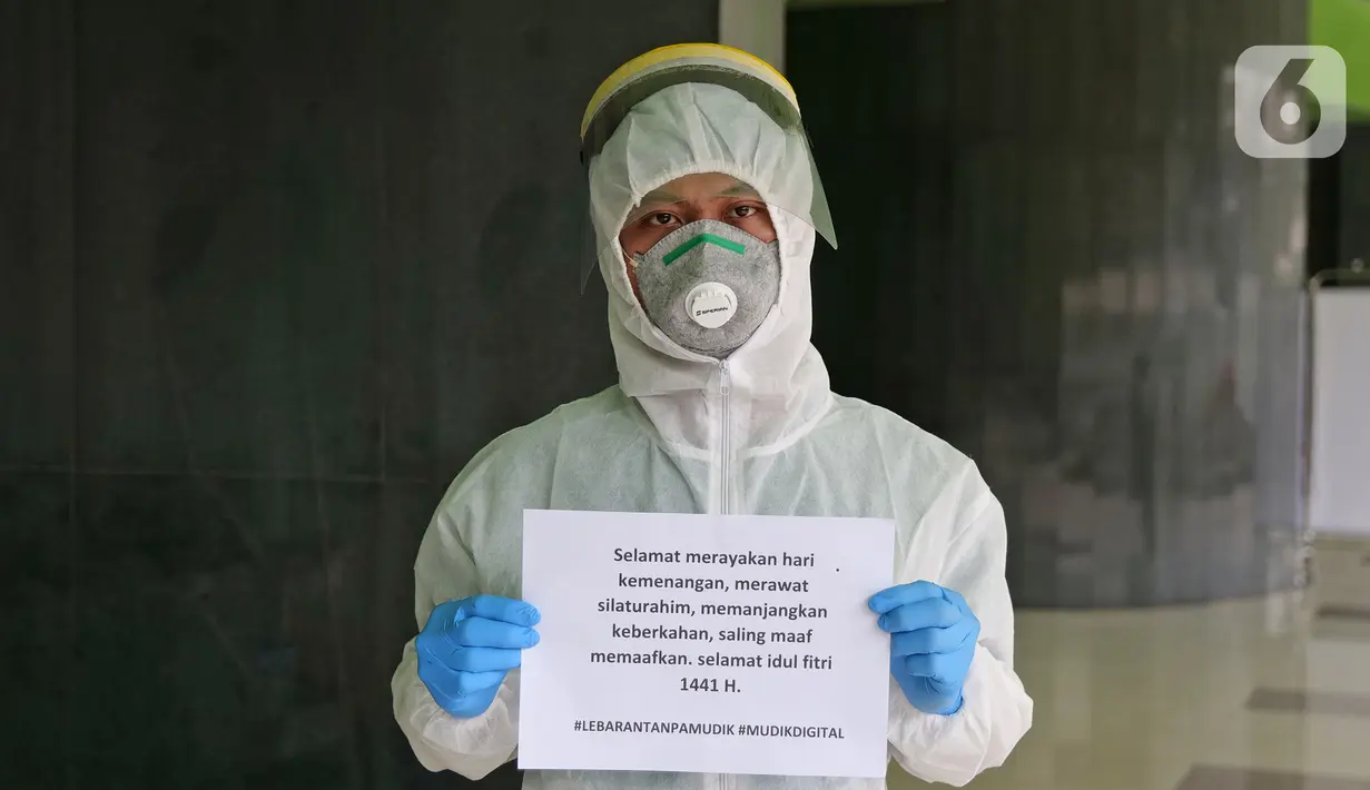 Petugas kebersihan Wahyu (26) menyampaikan pesan lewat sebuah tulisan saat di RSUD Pasar Minggu, Jakarta, Jumat (22/5/2020). Sejumlah garda terdepan Covid-19 menyampaikan pesan lewat sebuah tulisan. (Liputan6.com/Herman Zakharia)