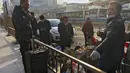 Buruh migran dengan barang bawaannya beristirahat di luar Stasiun Kereta Api Barat sebelum naik kereta di Beijing, Jumat (6/1/2023). China berupaya meminimalkan kemungkinan wabah COVID-19 yang lebih besar selama kesibukan perjalanan Tahun Baru Imlek bulan ini menyusul berakhirnya sebagian besar langkah-langkah pencegahan pandemi. (AP Photo/Wayne Zhang)