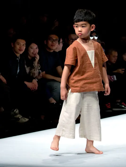 Gaya model cilik berpose mengenakan koleksi busana orang tua dan anak YIAN karya Lu Enhua selama China Fashion Week di Beijing, Sabtu 1 April 2017. (AP Photo / Mark Schiefelbein)