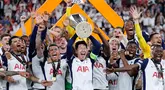 Pemain depan Tottenham Hotspur asal Korea Selatan, Son Heung-min mengangkat trofi Liga Europa saat merayakan kemenangan bersama rekan setimnya usai pertandingan final melawan Manchester United di stadion San Mames, Bilbao, pada 21 Mei 2025 waktu setempat atau Kamis (22/5) dini hari WIB. (Thomas COEX/AFP)