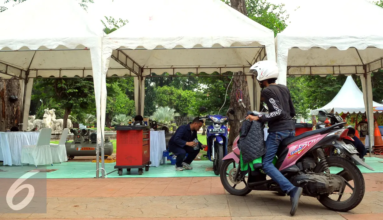 Pengunjung saat ingin menservice motornya di service di kawasan Lapangan Banteng, Jakarta, Jumat (11/12). Setiap harinya service motor terbatas 50unit/perhari, service geratis ini hanya bisa menservice kecil, ganti oli, dll. (Liputan6.com/Faisal R Syam)