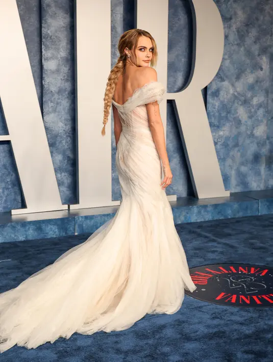 Cara Delavigne berpose saat menghadiri  After Party Vanity Fair Oscar 2023 di The Wallis Annenberg Center for the Performing Arts di Beverly Hills, California pada 12 Maret 2023. Cara juga memberikan sekilas banyak tato lengannya yang rumit saat dia berpose di pesta pasca-Oscar. (Amy Sussman/Getty Images/AFP)