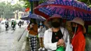 Para penumpang menunggu di halte bus selama hujan lebat di Hanoi (14/10/2020). Badai tropis Nangka menghantam Vietnam tengah-utara yang mengakibatkan bencana alam, terutama hujan lebat dan banjir, telah menyebabkan 28 orang tewas dan 12 lainnya hilang. (AFP Photo/Manan Vatsyayana)