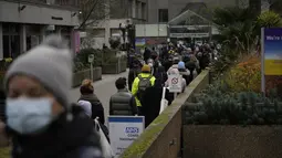 Orang-orang antre (kanan) untuk mendapatkan suntikan vaksin booster Covid-19 di Rumah Sakit St Thomas, London, Senin (13/12/2021). Perdana Menteri Inggris Boris Johnson pada Minggu (12/12) memperingatkan "gelombang pasang" yang meningkat akibat Varian Omicron. (AP Photo/Matt Dunham)