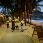 Karyawan restoran mengundang orang yang lewat saat para turis memanfaatkan program "Kotak Pasir Phuket" untuk pengunjung yang divaksinasi penuh terhadap virus corona Covid-19 di pulau Phuket Thailand (25/10/2021). (AFP/Mladen Antonov)