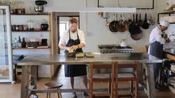 Chef Kobus van der Merwe menyiapkan hidangan di restoran Wolfgat di Paternoster, Afrika Selatan, 24 Februari 2019. Restoran ini menjadi istimewa karena semua bahan baku didapatkan secara liar dan alami dari area sekitar restoran. (Halden Krog/AFP)