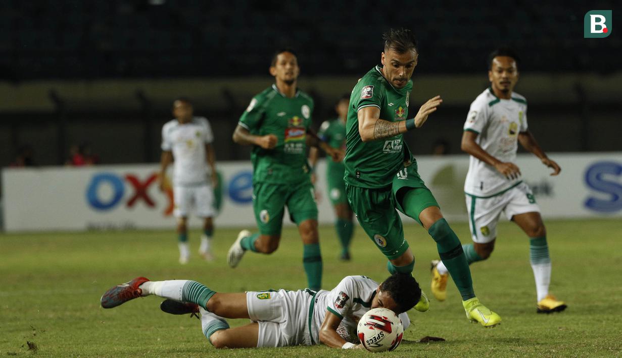 Striker PS Sleman, Velez Nicolas Leandro (tengah) menguasai bola saat melawan Persebaya Surabaya dalam laga Grup C Piala Menpora 2021 di Stadion Si Jalak Harupat, Bandung, Rabu (7/4/2021). (Bola.com/Ikhwan Yanuar)