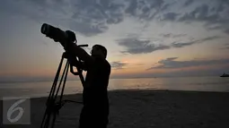 Seorang pria sedang mengabadikan Sunset di Pantai Sengigi, NTB (13/10/2015). Pulau Lombok terpilih sebagai pemenang dalam ajang internasional World’s Best Halal Travel Summit di Abu Dhabi, Uni Emirate Arab (UEA).(Liputan6.com/Gempur M Surya)