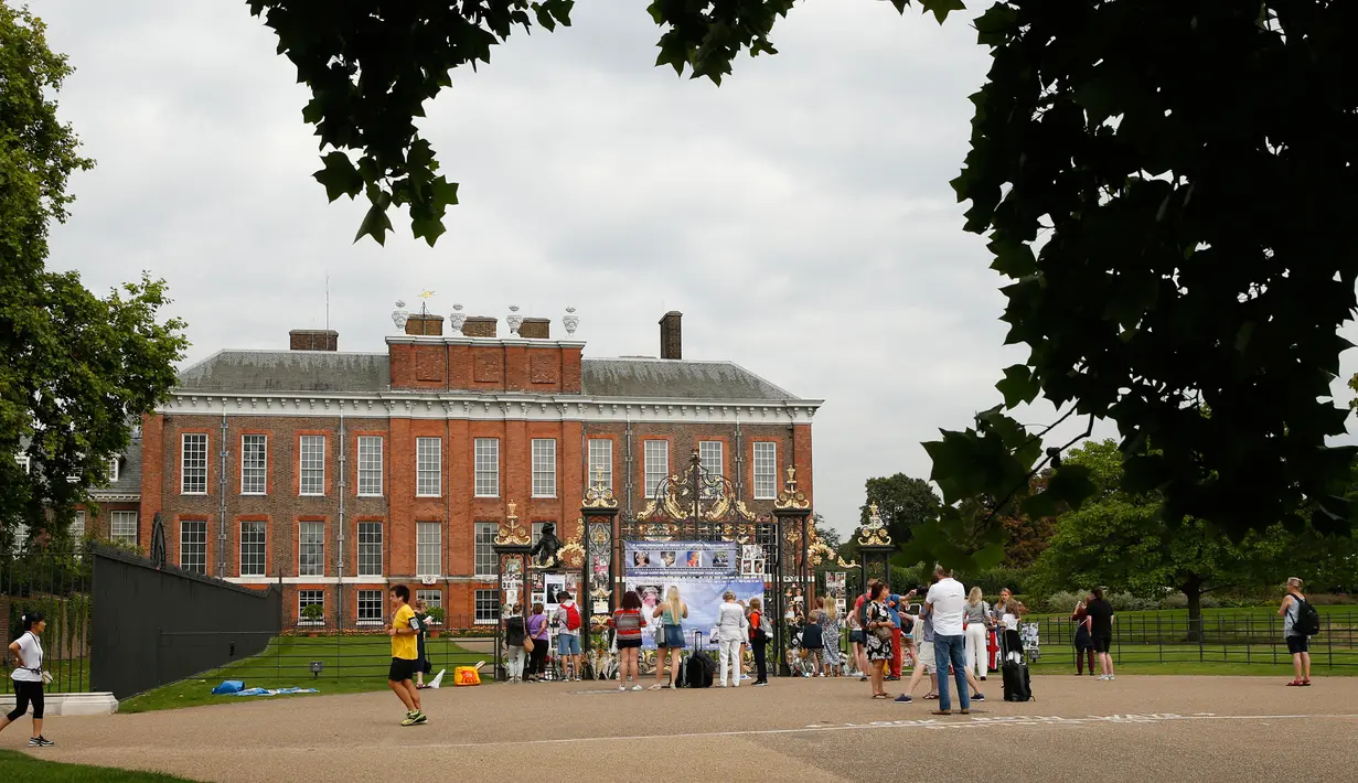 Sejumlah turis melihat memorabilia Putri Diana yang diletakkan di luar Istana Kensington, London, Selasa (29/8). Bunga, surat, foto, ungkapan duka juga lilin diletakkan di luar Istana untuk mengenang 20 tahun kematian Putri Diana (AP Photo/Alastair Grant)