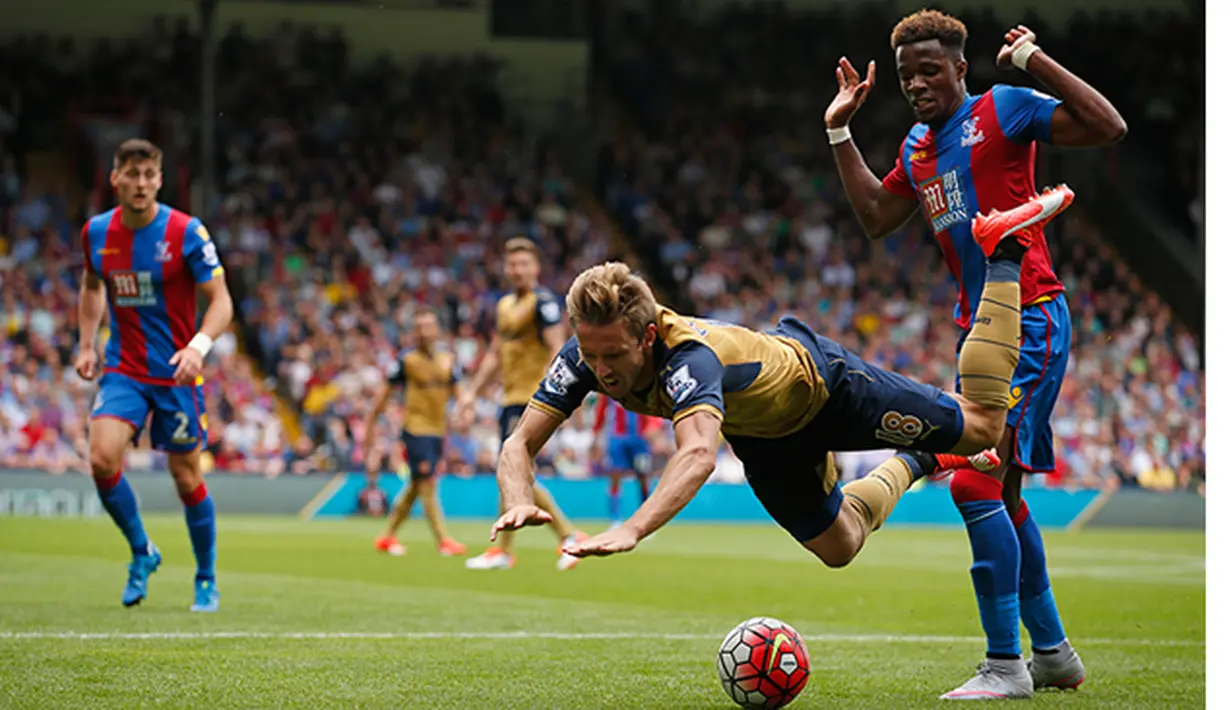 Pemain Crystal Palace, Wifried Zaha menjatuhkan pemain Arsenal, Nacho Monreal pada laga Liga Inggris di Stadion Selhurst Park, Inggris, Minggu (16/8/2015). Arsenal taklukan Palace 2-1. (Reuters/John Sibley)