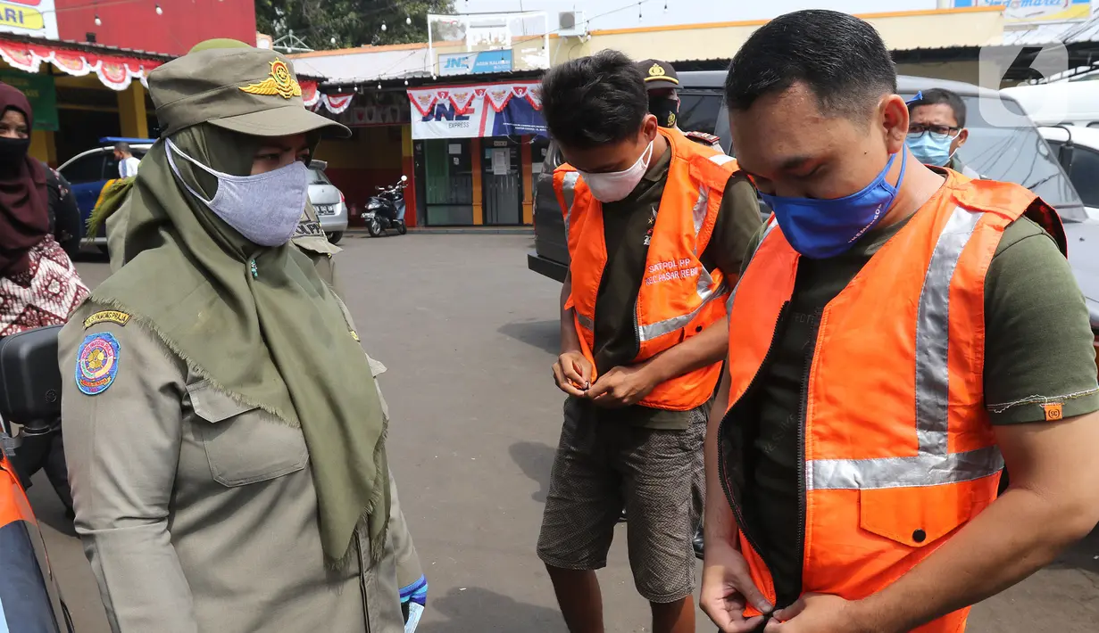 Petugas gabungan memberikan peringatan kepada warga pelanggar PSBB di Kawasan Kalisari, Pasar Rebo, Jakarta, Kamis (3/9/2020). Warga Pasar Rebo yang kedapatan tidak menggunakan masker diberikan pilihan hukuman, salah satunya dimasukkan ke dalam peti mati selama 1 menit. (Liputan6.com/Herman Zakharia