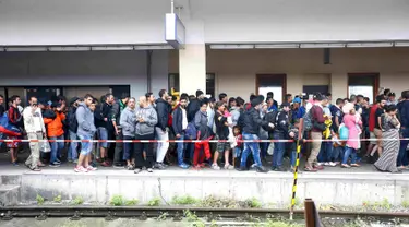 Sejumlah imigran berjalan saat tiba di stasiun kereta api Wina, Austria, Sabtu (5 /9/2015). Sekitar 2.000 imigran menembus Austria setelah pemerintah Hungaria mengizinkan para pencari suaka ke negara selanjutnya. (REUTERS/Dominic Ebenbichler)