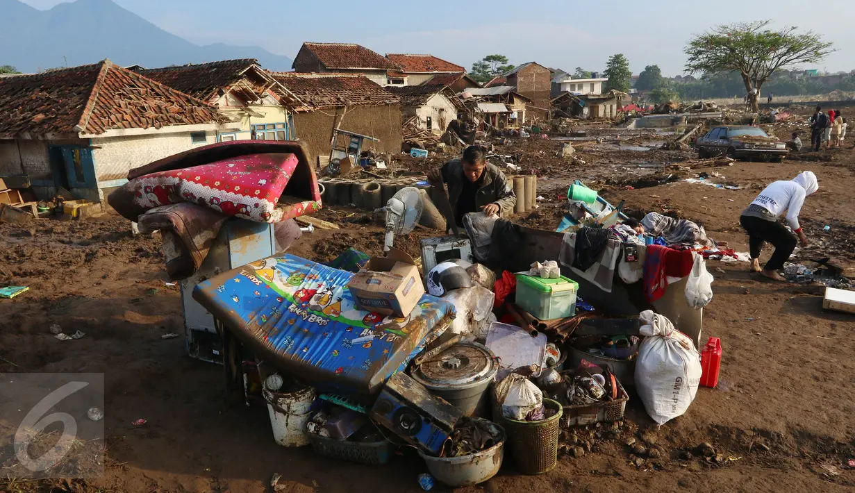 Warga mengumpulkan barang yang berhasil diselamatkan dari terjangan banjir bandang di Kampung Cimacan, Kecamatan Tarogong, Kabupaten Garut, Kamis (22/9). Data sementara Basarnas Jabar, 57 rumah hanyut dan 633 rumah terendam. (Liputan6.com/Johan Tallo)