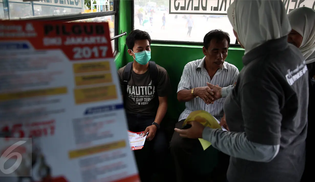 Petugas KPU membagikan brosur kepada penumpang bus saat sosialisasi Pilkada DKI 2017 di Terminal Senen, Jakarta, Minggu (18/12). Sosialisasi pesta demokrasi ini guna mencegah banyaknya pemilih yang golongan putih atau golput. (Liputan6.com/Johan Tallo)