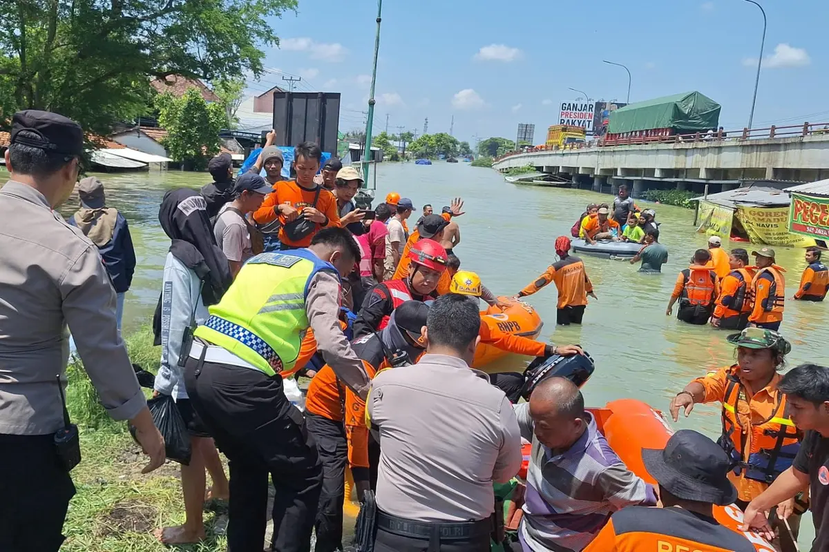 Personel Polres Kudus, TNI, BPBD dan instansi terkait serta relawan membantu proses evakuasi warga Karanganyar di barak pengungsian di perbatasan Kudus dan Demak. (Liputan6.com/Arief Pramono)
