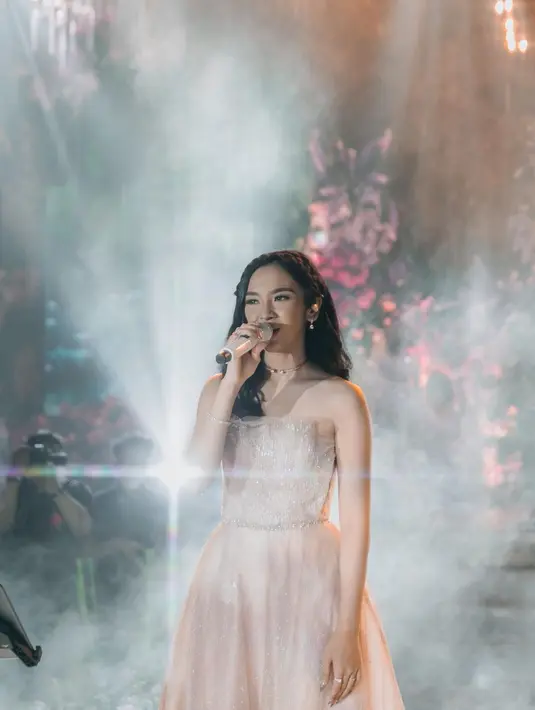 Sekali lagi, Lyodra tampak mengenakan off shoulder ball gown bernuansa netral yang super cantik. Dress ini memiliki detail banyak bordir dan payet berkilauan yang terlihat lebih mencolok saat disorot lampu panggung. Foto: Instagram.