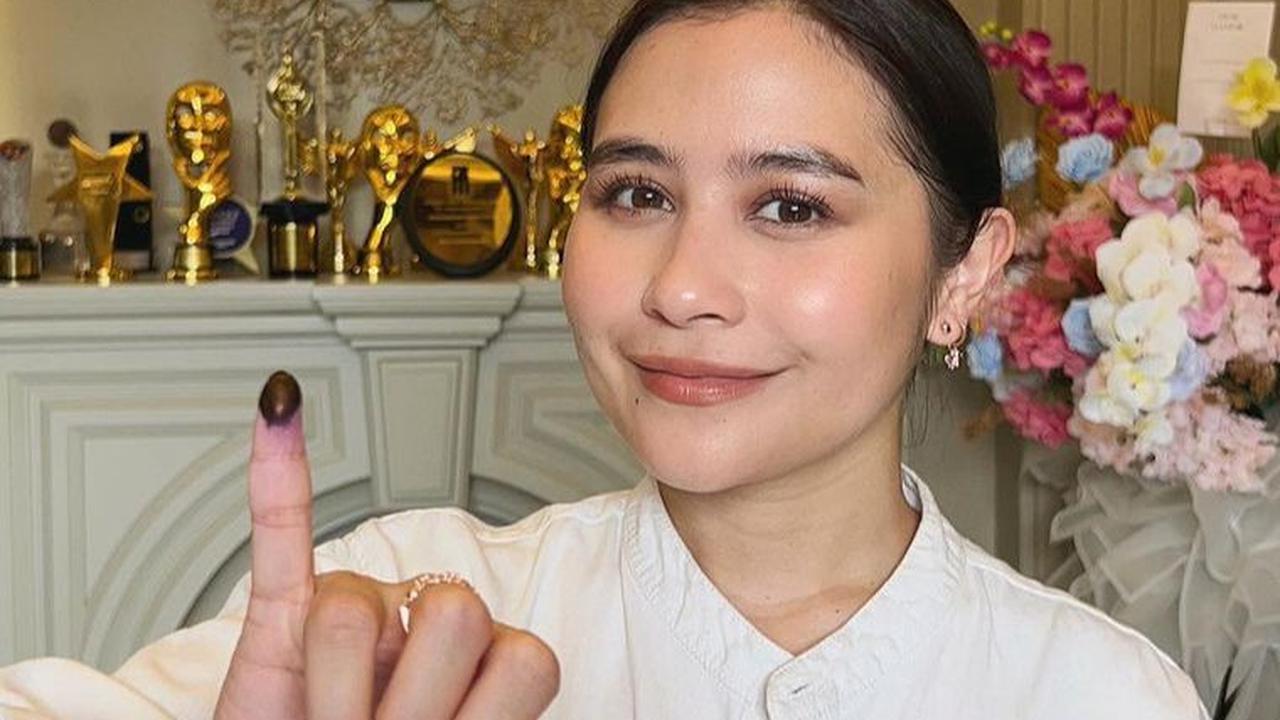 Prilly Latuconsina tampil cantik berbusana putih di hari pencoblosan. Dia menunjukkan jari kelingking bertinta tanda telah memberikan hak suara.