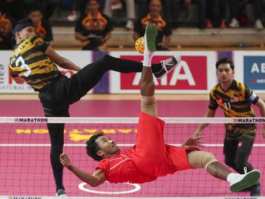 Pemain Tim Sepak Takraw Indonesia, Rusdi menendang bola ke arah Tim Sepak Takraw Malaysia pada laga final nomor ganda putra perorangan sepak takraw SEA Games 2023 di Olympic Stadium, Phnom Penh, Kamboja, Senin (15/05/2023). Indonesia berhasil menang dengan skor skor 14-21, 21-16, dan 21-13. (AP Photo/Tatan Syuflana)