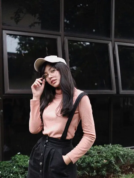 Seperti di foto ini contohnya, gaya Vanesha vintage banget. Ia memakai overall berwarna hitam dengan dalaman turtle neck berwarna pink. Paduan topi dan kacamata ini membuat penampilannya semakin unik. (Instagram/vaneshaass)