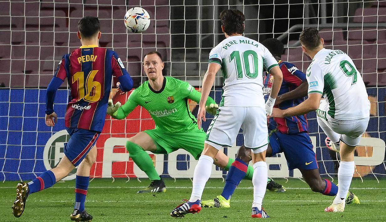 Striker Elche, Lucas Boye (kanan) melepaskan tendangan yang siap diantisipasi kiper Barcelona, Marc-Andre ter Stegen (tengah) dalam laga lanjutan Liga Spanyol 2020/21 pekan ke-24 di Camp Nou Stadium, Barcelona, Rabu (24/2/2021). Elche kalah 0-3 dari Barcelona. (AFP/Lluis Gene)