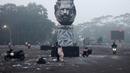 Pengendara sepeda motor melintas di luar Stadion Kanjuruhan pada pagi hari setelah tragedi kerusuhan pada pertandingan sepak bola antara Arema dan Persebaya di Malang, Jawa Timur, Minggu (2/10/2022). Ratusan nyawa melayang pada kerusuhan usai Persebaya mengalahkan Arema tersebut. (PUTRI/AFP)