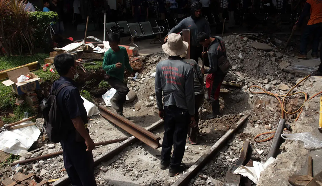 Sejumlah pekerja PT KAI melakukan perbaikan pembatas antara rel dan ruang tunggu penumpang di Stasiun Kota, Jakarta, Jumat (26/12/2014). (Liputan6.com/Faizal Fanani)