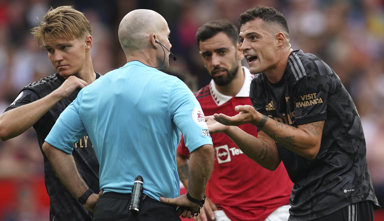 Wasit yang memimpin laga Manchester United melawan Arsenal, Paul Tierney menganulir gol yang dicetak Gabriel Martinelli pada menit ke-12 usai meninjau VAR. Sebelum gol terjadi, Martin Odegaard terlebih dahulu melakukan pelanggaran terhadap Christian Eriksen. (AP Photo/Dave Thompson)