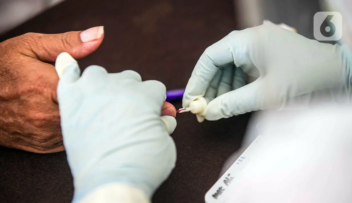 Petugas medis mengambil sampel darah warga saat rapid test gratis di Pos Pengamanan Natal 2020 dan Tahun Baru 2021 Polsek Kebayoran Lama, Jakarta, Selasa (29/12/2020). Rapid test itu dilakukan untuk membantu mengurai antrean warga saat tes di tempat lainnya. (Liputan6.com/Faizal Fanani)