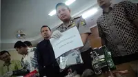 Petugas menunjukan barang bukti dalam penggerebekan di Universitas Nasional (UNAS) di Mapolres Jakarta Selatan, Jumat (15/8/14). (Liputan6.com/Faizal Fanani)