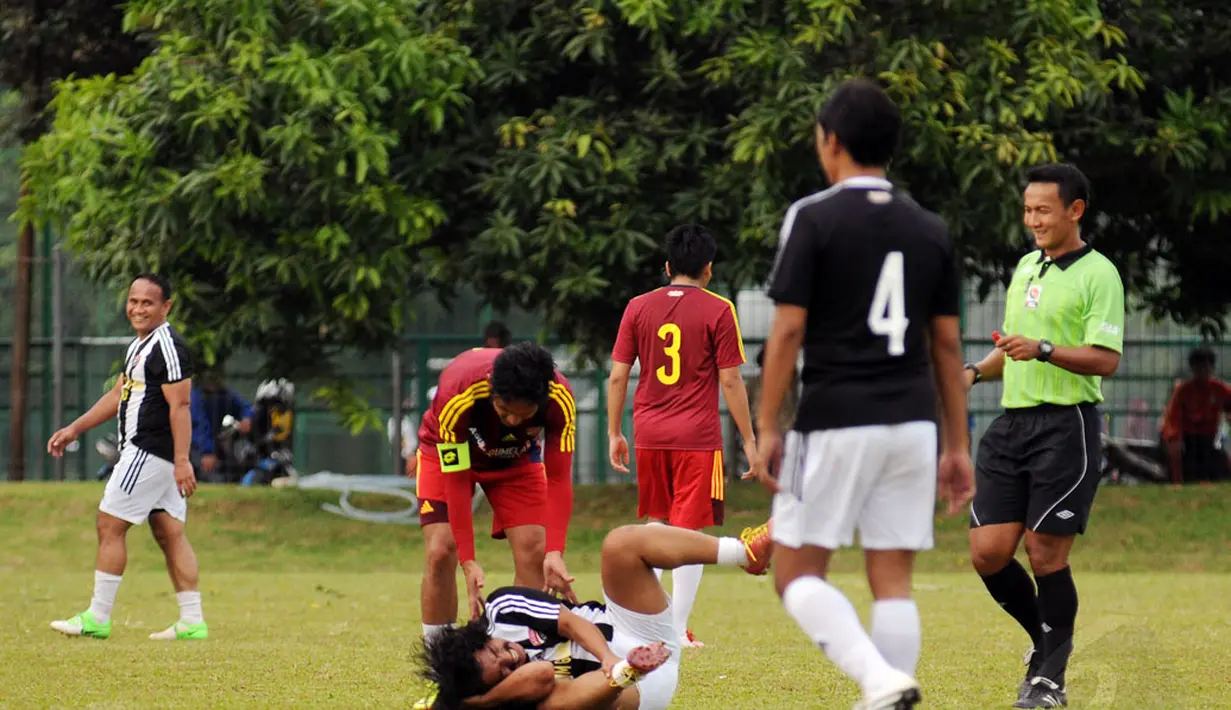 Pemain depan Paski-Man FC, Ajul Jiung terkapar usai dijegal salah satu pesepak bola Selebriti FC di turnamen Agum Gumelar Cup di Lapangan C Senayan, Jakarta (9/1/2015). Paski-Man FC unggul 1-0 atas Selebrity FC. (Liputan6.com/Helmi Fithriansyah)