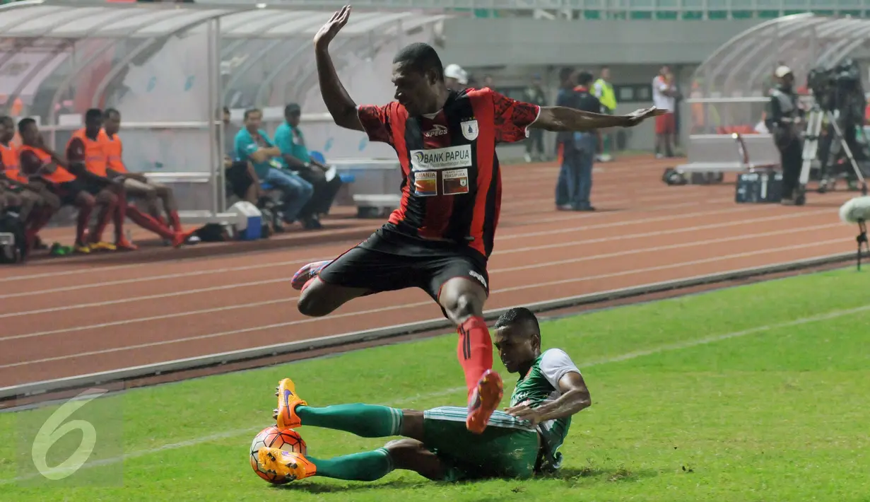 Bek PS TNI Abduh Lestaluhu (bawah) mencoba menahan bola saat laga melawan Persipura di lanjutan Torabika Soccer Championship presented by IM3 Ooredoo di Stadion Pakansari Kab Bogor, Minggu (19/6). PS TNI kalah 1-3. (Liputan6.com/Helmi Fithriansyah)
