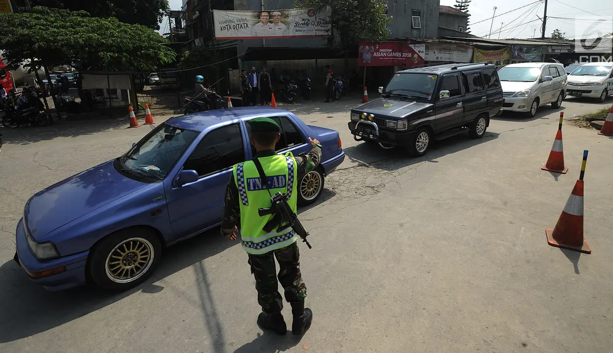 Prajurit TNI AD mengatur kendaraan saat pola buka tutup diberkakuan pada ruas tol fungsional Bogor-Sukabumi di Cicurug, Sukabumi (16/6). Kemacetan terjadi sepanjang lebih dari lima kilometer pada jalan arteri Ciawi-Sukabumi. (Merdeka.com/Arie Basuki)