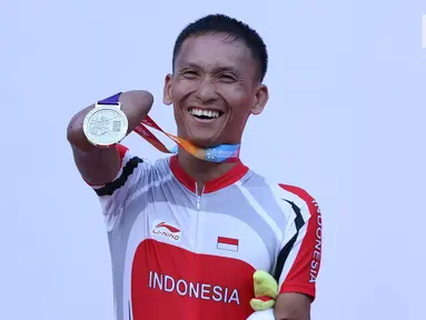 Atlet ParaCycling, Anwar Saipul memperlihatkan medali perak nomor Mens C3 Individual Time Trial Road Race Asian Para Games 2018 usai prosesi pengalungan medali di Sirkuit Sentul, Bogor, Senin (8/10). (Liputan6.com/Helmi Fithriansyah)