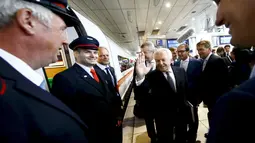 Ruediger Grube (tengah), CEO dari kereta api Jerman Deutsche Bahn AG, menyapa staf gabungan dari kereta api sebelum naik perdana kereta ICE kecepatan tinggi di Stasiun Kereta Api, Jerman, Kamis (23/7). (REUTERS/Kai Pfaffenbach) 