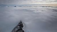 Puncak gunung dikelilingi laut es mengapung di lepas pantai Antartika (31/10). (Mario Tama/Getty Images/AFP)