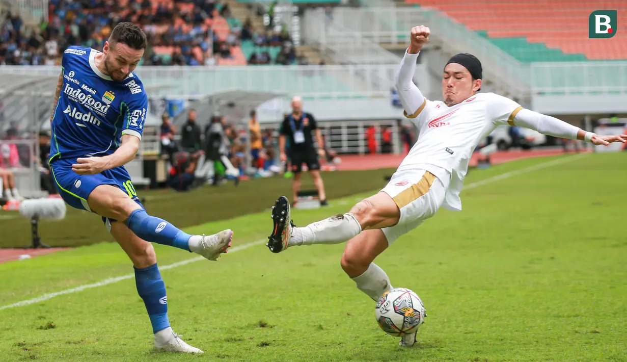 <p>Pemain Persib Bandung, Marc Klok (kiri) menendang bola dibayangi pemain PSM Makassar, Kenzo Nabu saat laga lanjutan BRI Liga 1 2022/2023 antara Persib Bandung melawan PSM Makassar di Stadion Pakansari, Bogor, Selasa (14/02/2023). (Bola.com/Bagaskara Lazuardi)</p>