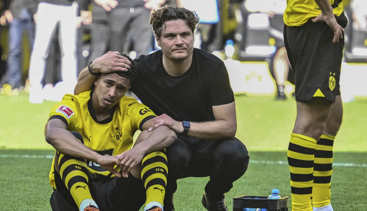 Kenyataan pahit harus diterima skuad Borussia Dortmund setelah berakhirnya laga pekan terakhir Liga Jerman 2022/2023 menghadapi FSV Mainz di Dortmund, Jerman, Sabtu (27/5/2023). Hanya bermain imbang 2-2, gelar juara yang sudah di depan mata pun melayang ke Bayern Munchen. Aura kesedihan dan kekecewaan pun menyelimuti seluruh anggota skuad Borussia Dortmund, seperti yang terekam dalam beberapa foto berikut ini. (AP Photo/Michael Probst)