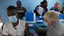 Seorang pria disuntik vaksin COVID-19 di sebuah lokasi dekat Johannesburg, Rabu (8/12/2021). Kasus Omicron telah dikonfirmasi setidaknya di sembilan negara Afrika, dengan Afrika Selatan tetap menjadi episenter awal ditemukannya varian baru tersebut. (AP Photo/Denis Farrell)