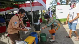 Warga mencuci tangan sebelum melakukan pemungutan suara pada Pilkada Tangerang Selatan di TPS 49 Cendana Residence, Pondok Benda, Pamulang, Rabu (9/12/2020). TPS 49 pada Pilkada Serentak 2020 mengusung tema Rindu Sekolah Lagi (Kisah-Kasih di Sekolah). (Liputan6.com/Fery Pradolo)