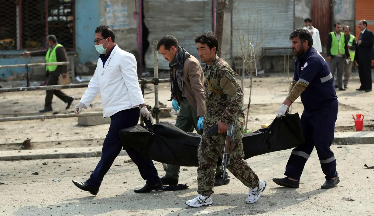 Petugas keamanan mengevakuasi korban tewas dari lokasi serangan bunuh diri di Kabul, Afganistan, (9/3). Serangan bom ini menewaskan sekitar sembilan orang dan melukai belasan lainnya. (AP Photo / Massoud Hossaini)