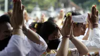 Umat Hindu Bali berdoa saat merayakan Hari Raya Kuningan di Pura Sakenan, Bali, Sabtu (18/6/2022). Kuningan menandai hari terakhir perayaan Galungan, salah satu upacara keagamaan terbesar umat Hindu di Bali. (AP Photo/Firdia Lisnawati)