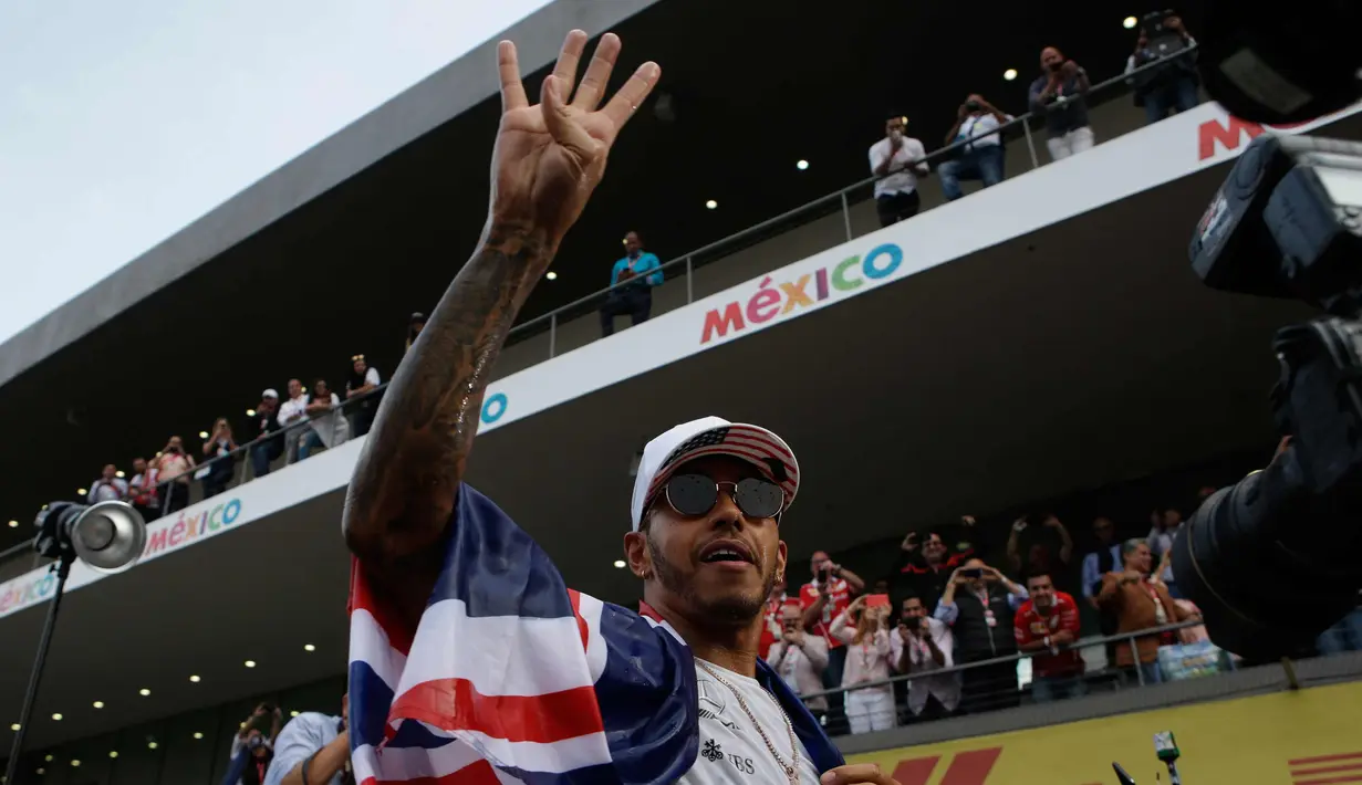 Pembalap asal Inggris dari tim Marcedes, Lewis Hamilton merayakan kemenangannya meraih juara dunia F1 untuk yang ke empat kalinya di Autodromo Hermanos Rodrigue, Meksiko (29/10). (AP Photo / Rebecca Blackwell)