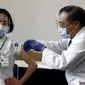 Seorang pekerja medis menerima dosis vaksin virus corona COVID-19 di Tokyo Medical Center, Tokyo, Jepang, Rabu (17/2/2021). Jepang memulai kampanye vaksinasi COVID-19 dengan suntikan COVID-19 pertama diberikan kepada petugas kesehatan. (Behrouz Mehri/Pool Photo via AP)