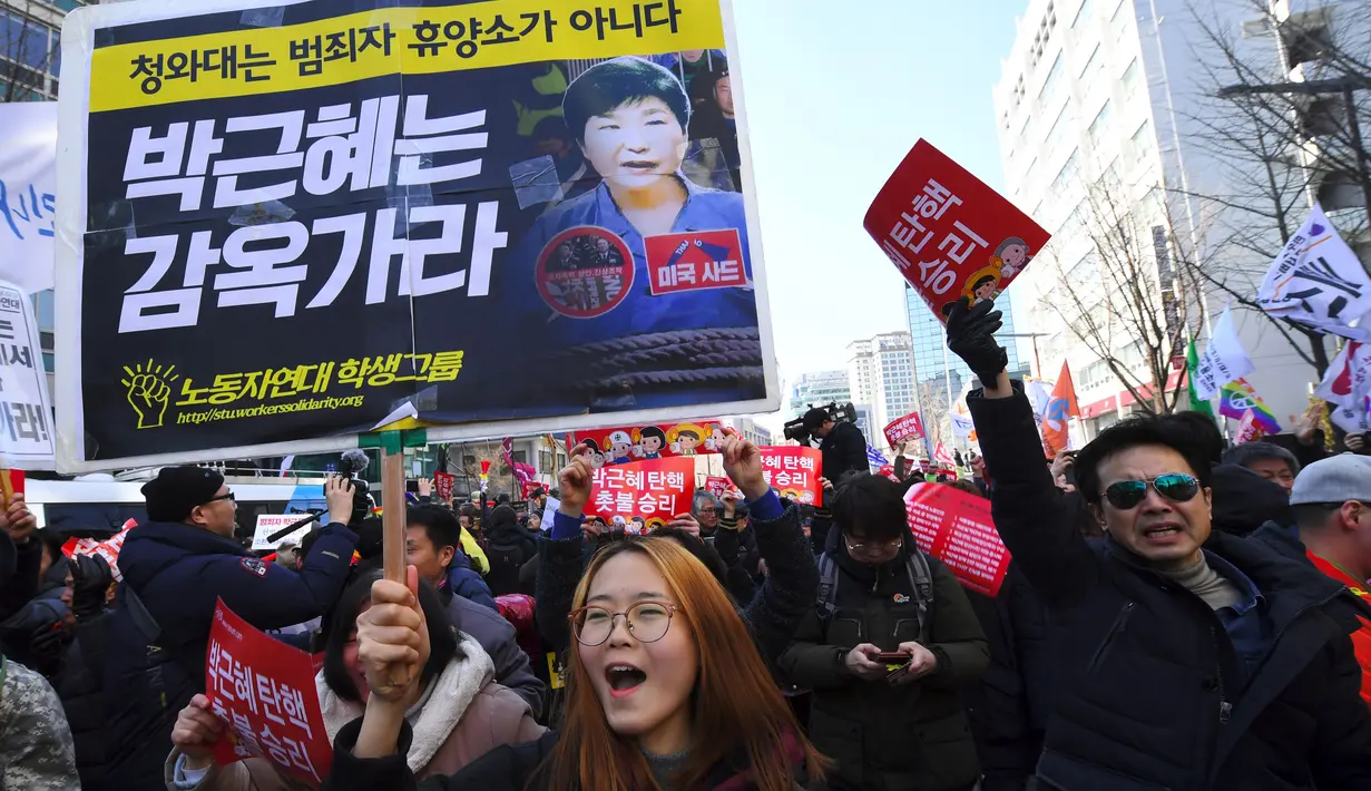 Aktivis anti-pemerintah membawa spanduk sambil merayakan pemakzulan Presiden Korea Selatan Park Geun-hye oleh Mahkamah Konstitusi di Seoul, Jumat (10/3). MK Korsel menyatakan Presiden Park Geun-Hye telah melanggar Konstitusi dan hukum. (JUNG Yeon-Je/AFP)