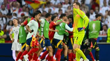 Ekspresi penjaga gawang Jerman, Manuel Neuer saat para pemain Spanyol merayakan kemenangan pertandingan perempat final Euro 2024 di Stuttgart Arena, Stuttgart, 5 Juli 2024 atau Sabtu 6 Juli 2024 dini hari WIB. (THOMAS KIENZLE/AFP)