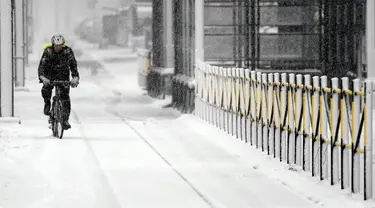 Seorang pria mengendarai sepeda melalui jalan yang tertutup salju di Beograd, Serbia, Minggu (12/12/2021).  Ahli meteorologi memperkirakan hujan salju lebat dan suhu di bawah nol di Balkan Barat sepanjang minggu. (AP Photo/Darko Vojinovic)