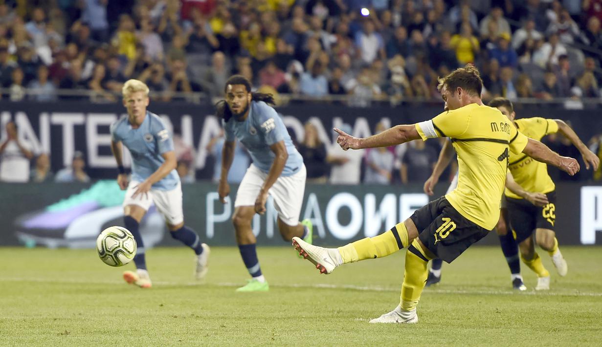 Pemain Borussia Dortmund, Mario Gotze saat mencetak gol melalui titik putih ke gawang Manchester City pada laga International Champions Cup 2018 di Soldier Field, Chicago, (20/7/2018), waktu setempat. Drtmund menang 1-0. (AP/Annie Rice)