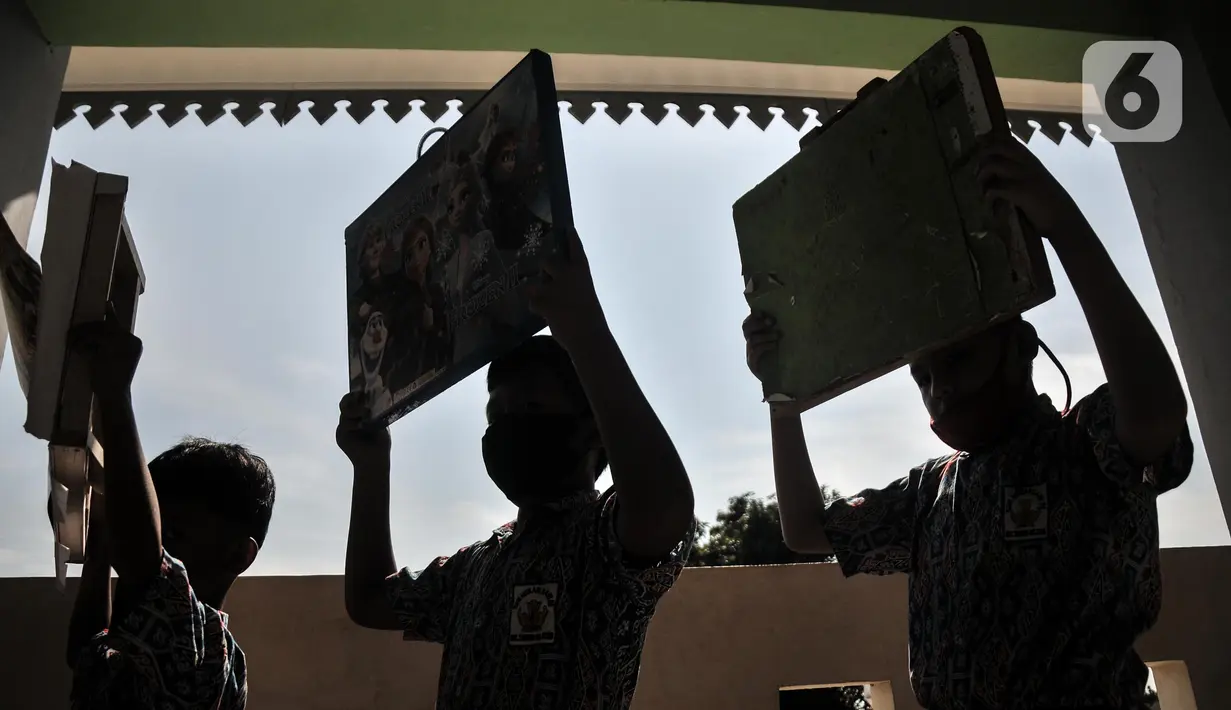 Murid membawa meja lipat saat tiba di Sekolah Dasar Negeri (SDN) Mekarsari 05, Tambun Selatan, Kabupaten Bekasi, Jawa Barat, Kamis (28/7/2022). Menurut salah seorang wali murid, ruang kelas tanpa fasilitas dasar tersebut sudah terjadi sejak 7 bulan lalu pasca gedung sekolah direnovasi dan hingga kini belum disediakan oleh Dinas Pendidikan setempat. (merdeka.com/Iqbal S. Nugroho)