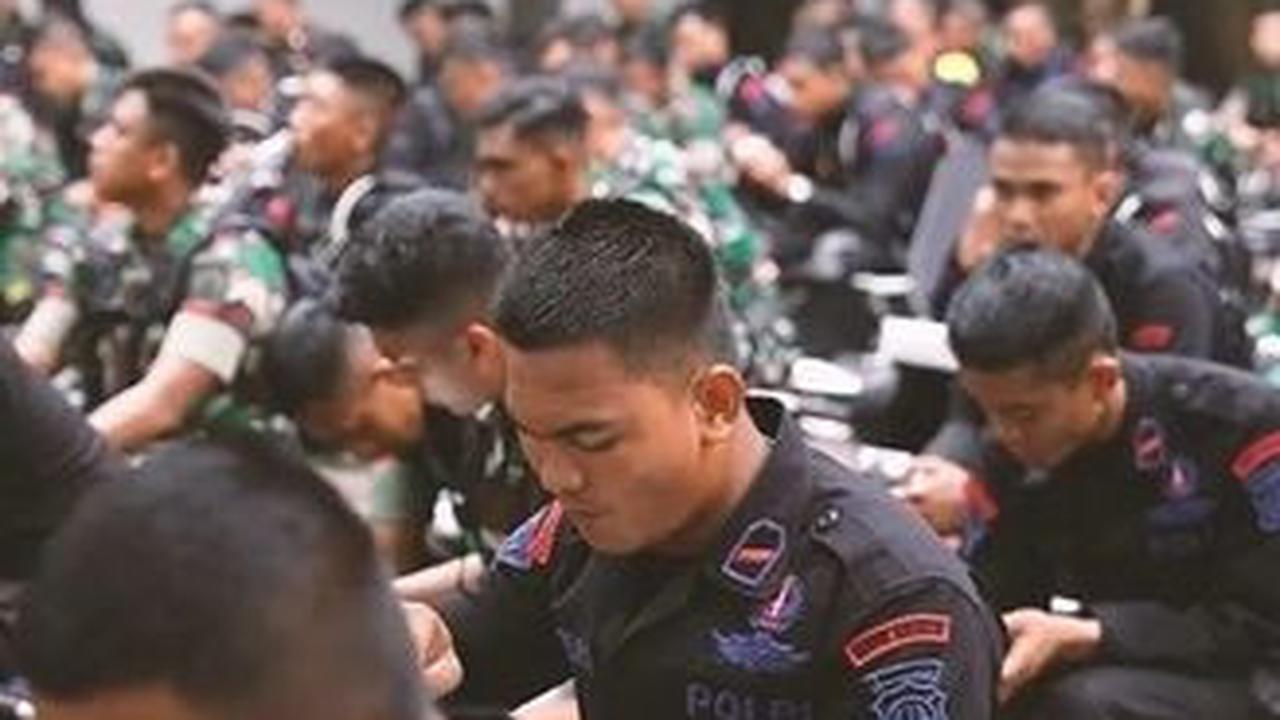 Sementara di hadapan mereka duduk ratusan prajurit TNI dan anggota Brimob yang bersiap akan makan siang bersama.