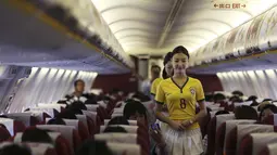 Penampilan pramugari tersebut terlihat semakin menarik dan cantik dengan panduan kaos bola dan rok pendek, China, Senin (23/6/14). (REUTERS/Wong Campion)